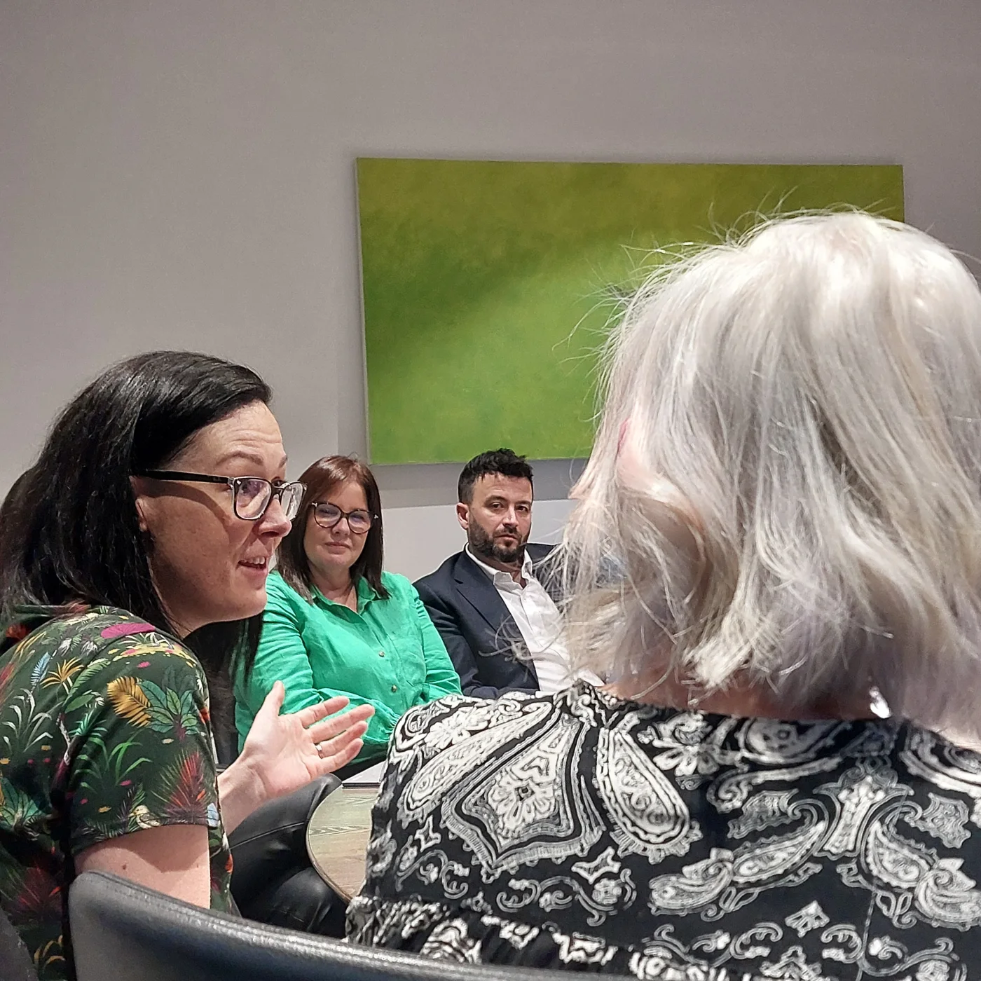 Clare E Kenny talking with leaders around a table